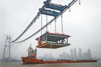 每台吊机起重能力达900吨,两台一起吊起千吨钢梁